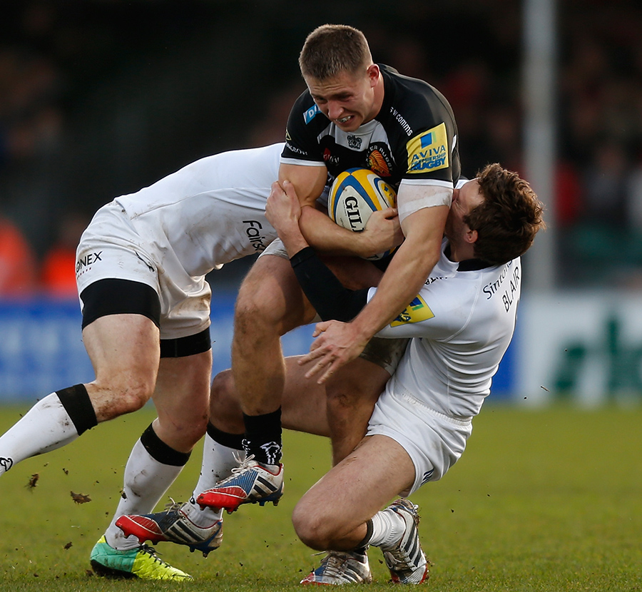 Exeter's Sam Hill attemps to barge through the attentions of two Newcastle Falcons