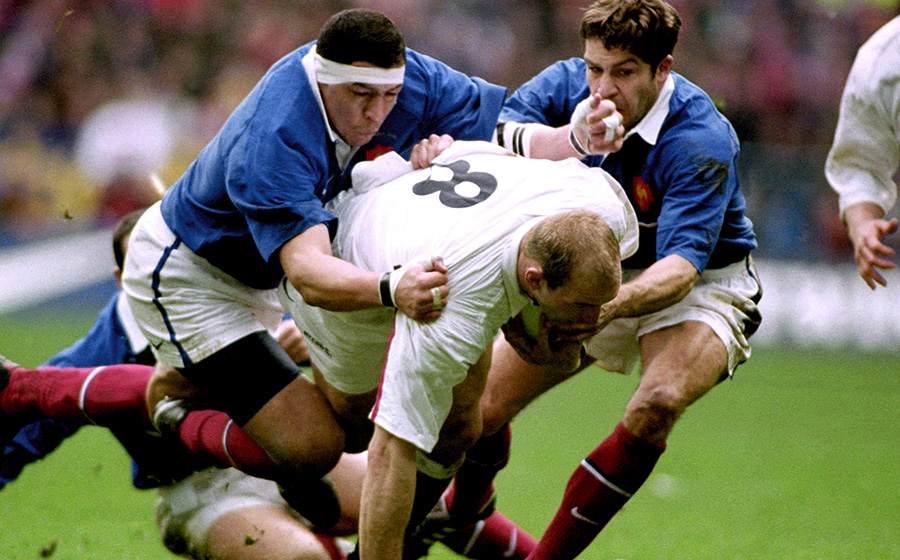 England's Lawrence Dallaglio is tackled by France's Abdelatif Benazzi and Thomas Lombard