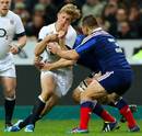 England's Billy Twelvetrees feels the force of the French