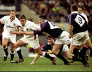 Jonny Wilkinson tries to escape the attention of Scotland's Scott Murray on the way to a 24-21 England victory