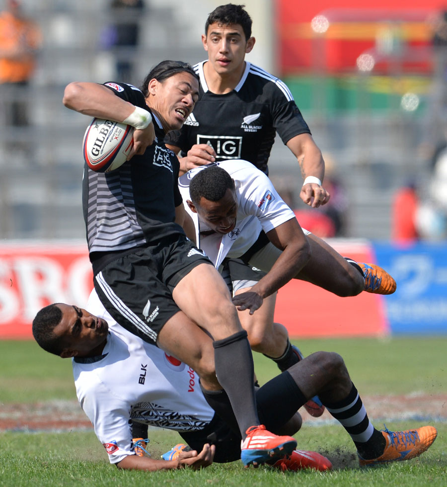 New Zealand's Ben Lam is tackled by Fiji's players Donasio Ratubuli Naturaga and Samisoni Viriviri