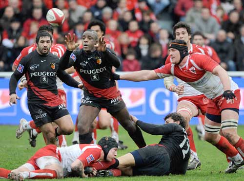 Toulouse's flanker Yannick Nyanga offloads the ball under pressure from Biarritz's Jerome Thion