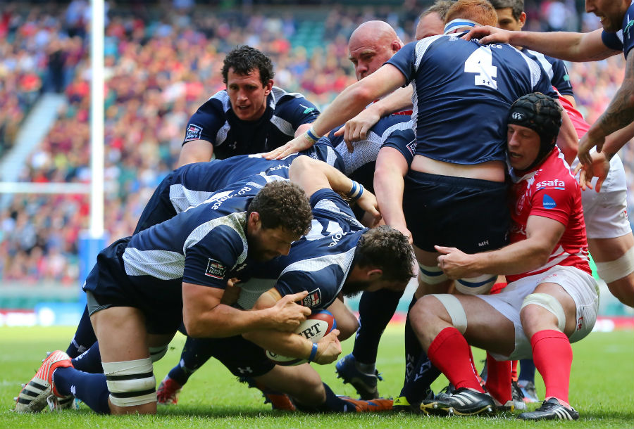 The Navy's Ben Priddey is helped over the line to score a try against The Army