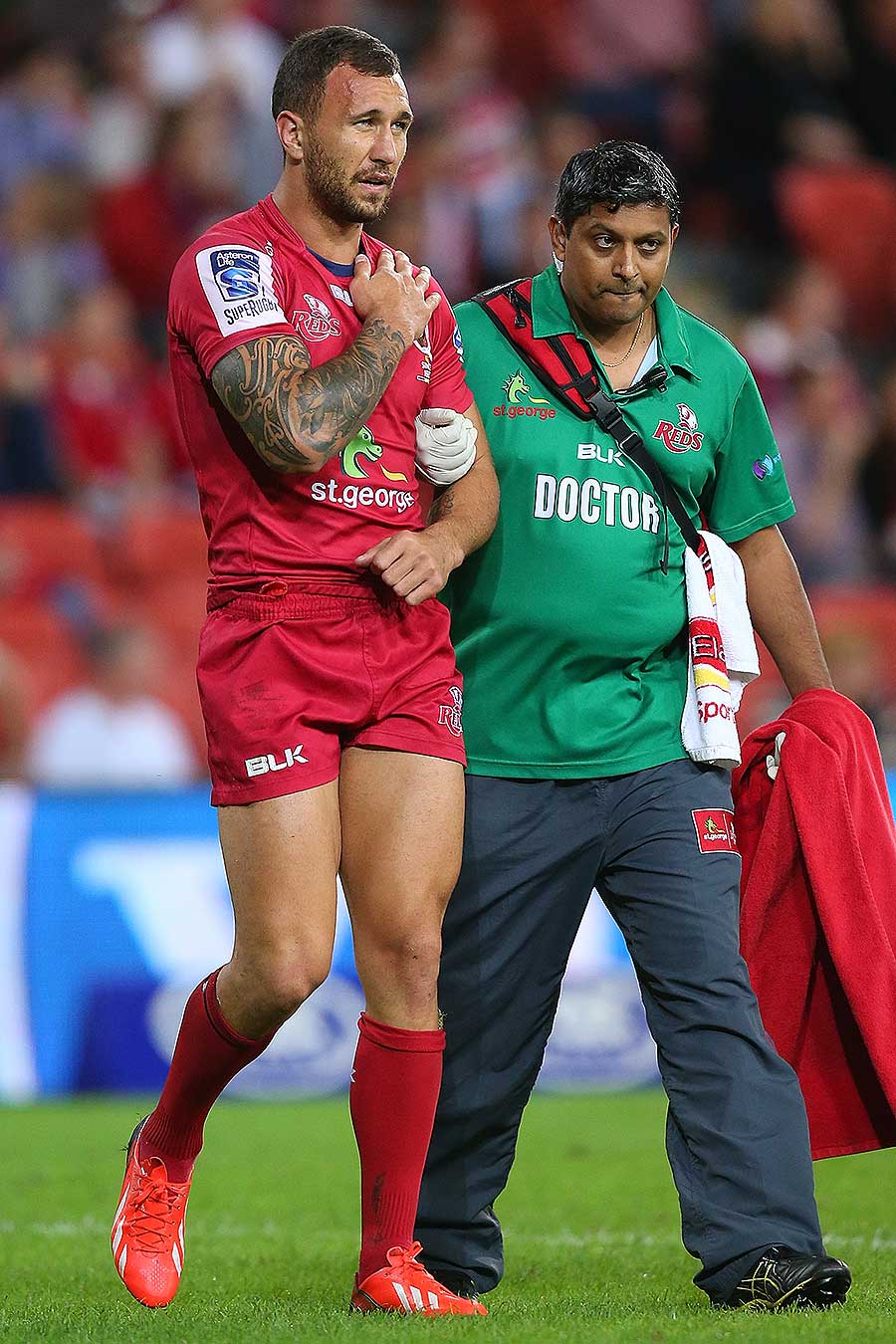The Reds' Quade Cooper leaves the pitch with a shoulder injury