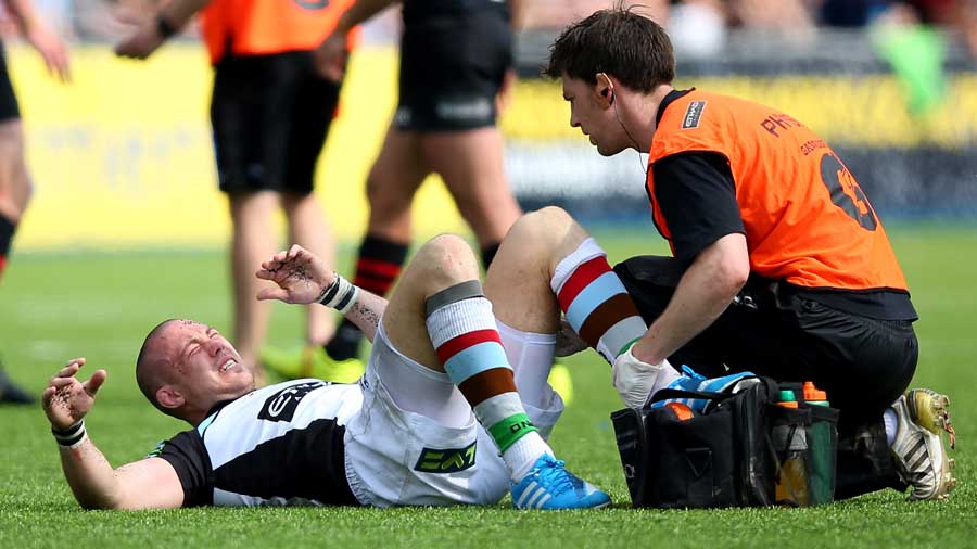 Harlequins' Mike Brown receives treatment for an injury