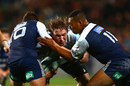 The Sharks' Etienne Oosthuizen is stopped in his tracks by Simon Hickey and Tevita Li of the Blues