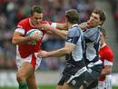 Wales' Lee Byrne fends off Scotland's Sean Lamont and Mike Blair
