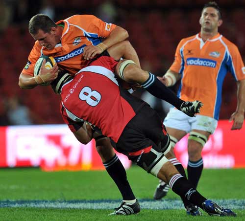 The Cheetahs' David de Villiers is tackled by the Lions' Willem Alberts
