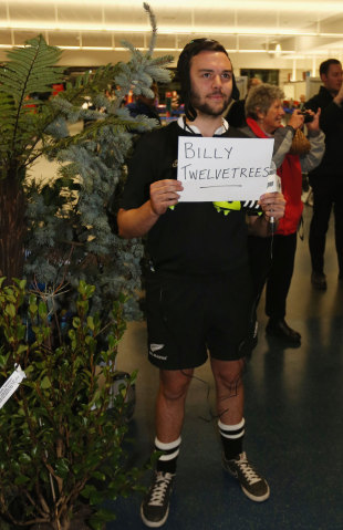A local television presenter who brought along twelve trees, waits to greet Bill Twelvetrees, Dunedin airport, June 12, 2014