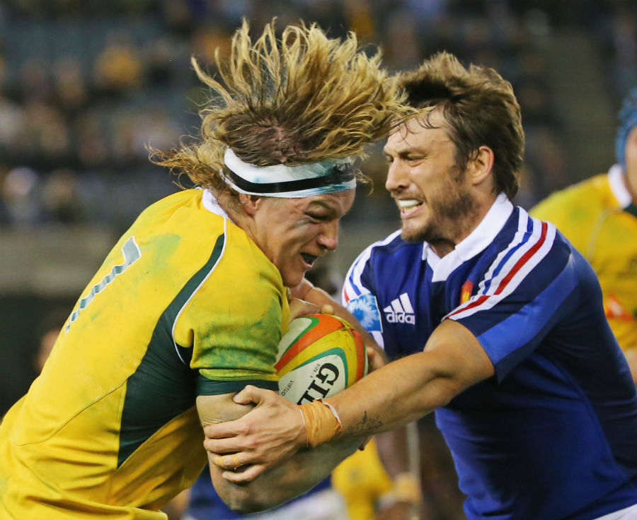 Michael Hooper is tackled by Maxime Medard