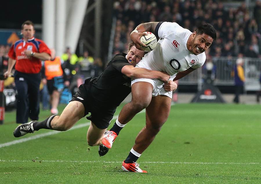 Manu Tuilagi of England is caught in a try saving tackle by Ben Smith