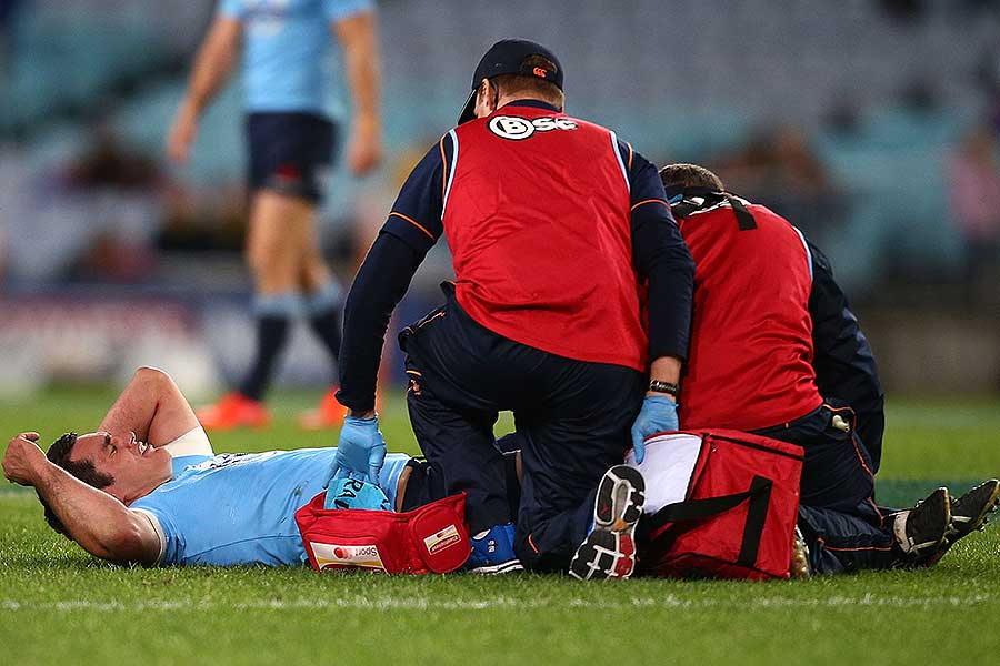 The Waratahs' Dave Dennis receives attention for a knee injury