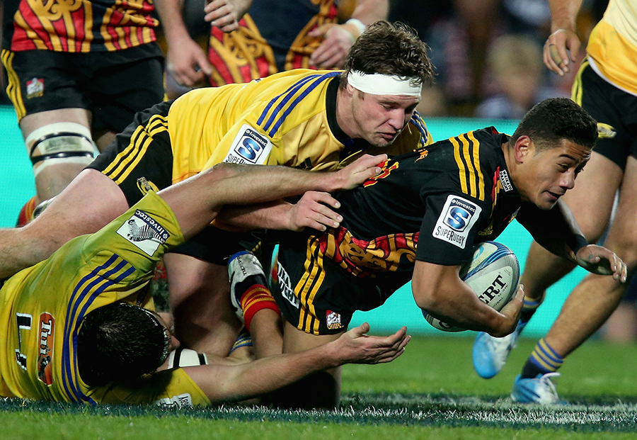 The Chiefs' Agustine Pulu is brought down by Reggie Goodes of the Hurricanes