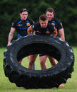 Henry Slade flips a tyre in the rain during an Exeter Chiefs training session