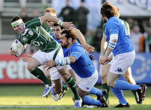 Ireland's Paddy Wallace is tackled by Italy's Fabio Ongaro