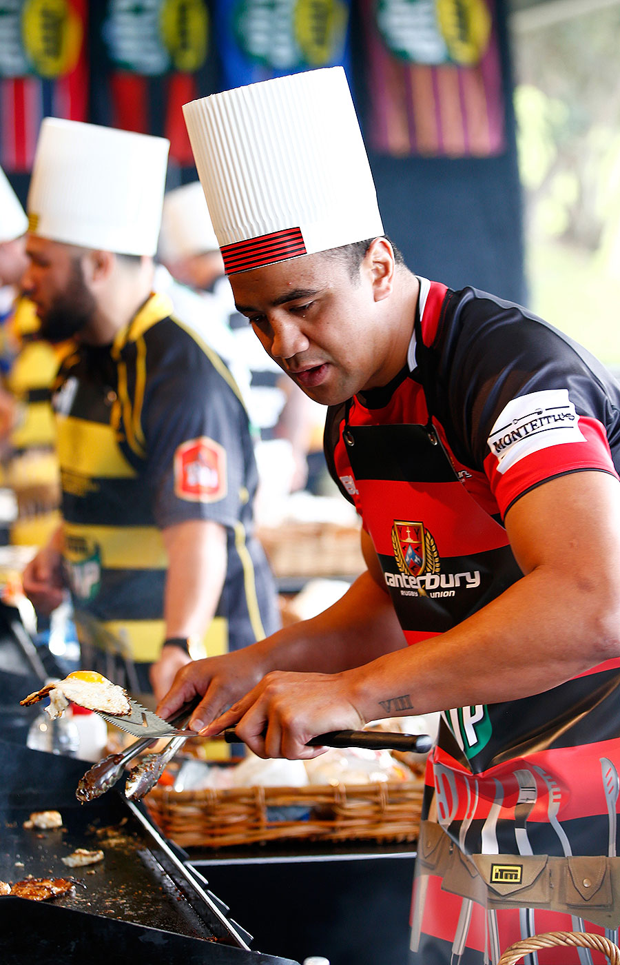 Canterbury's Nasi Manu cooks during a hamburger competition at the ITM Cup season launch