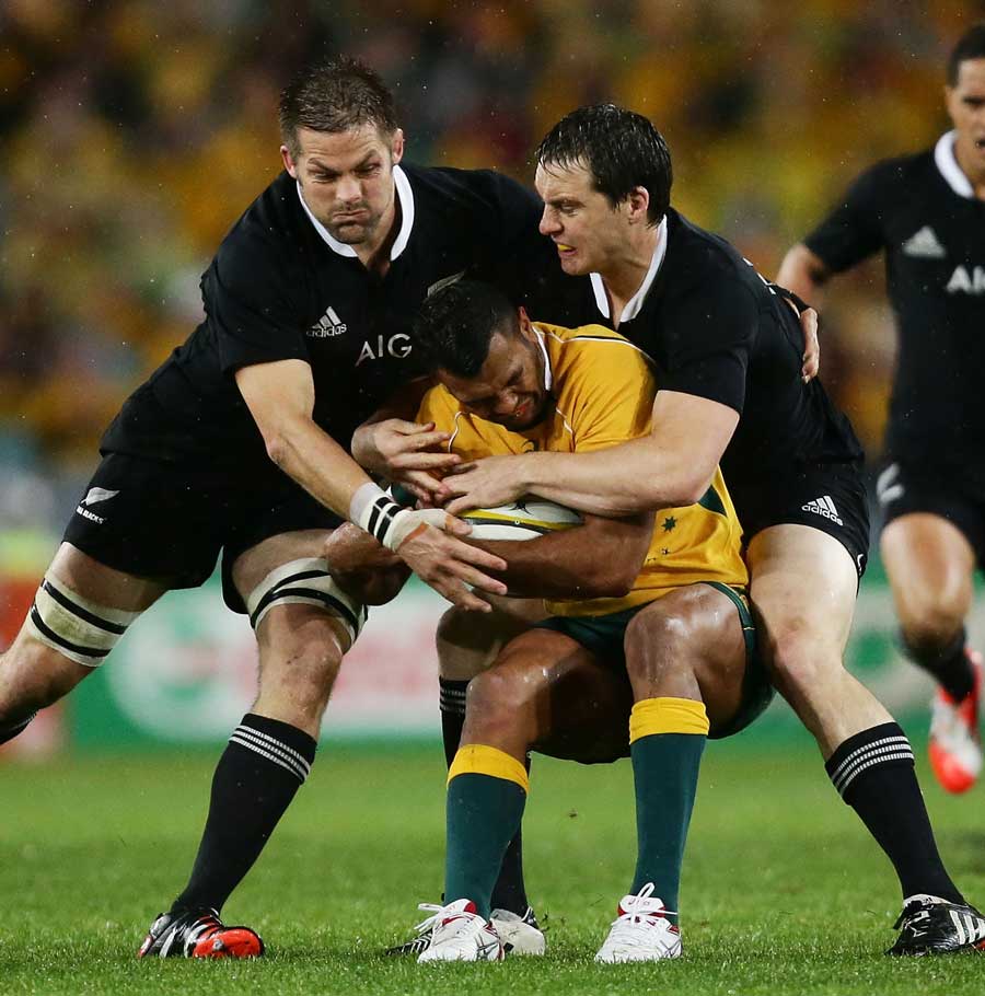 Australia's Kurtley Beale is wrapped up by the New Zealand defence
