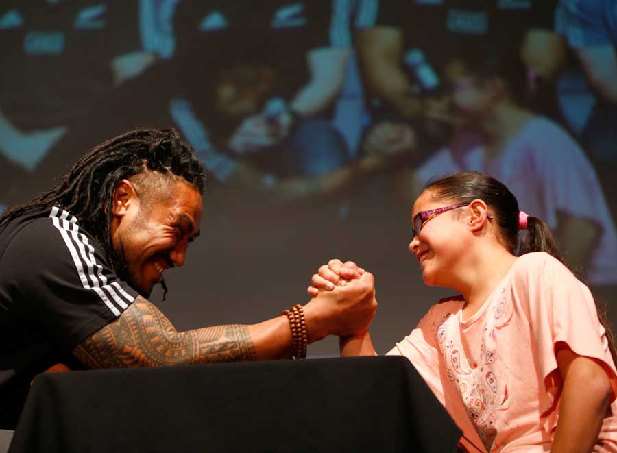 New Zealand's Ma'a Nonu takes on a young supporter at arm-wrestling