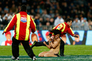 A streaker is tackled after making a dash across the field during the New Zealand v Argentina match