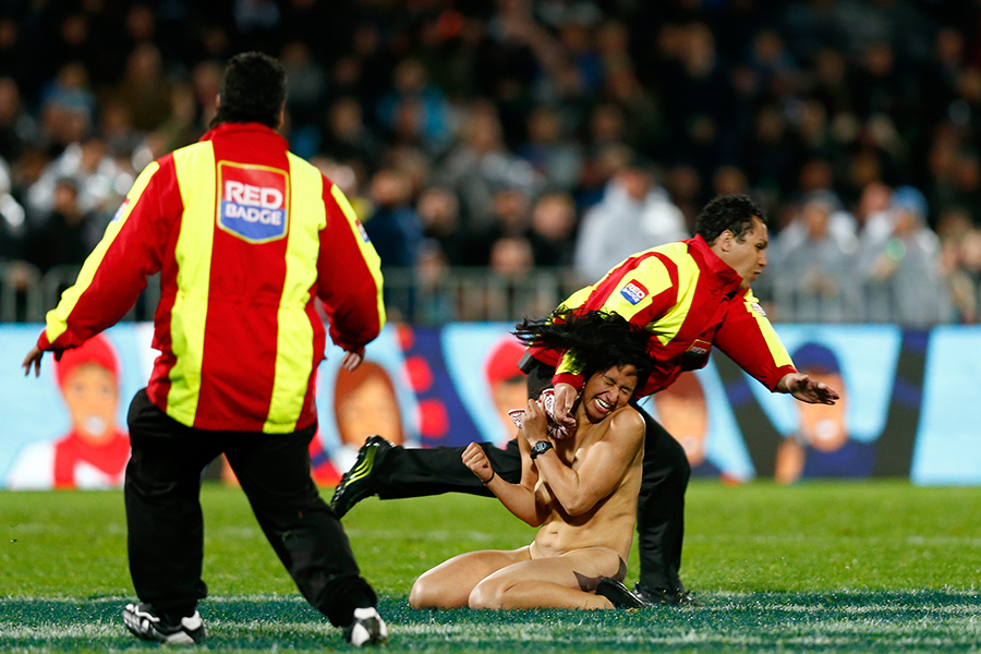 A streaker is tackled after making a dash across the field during the New Zealand v Argentina match