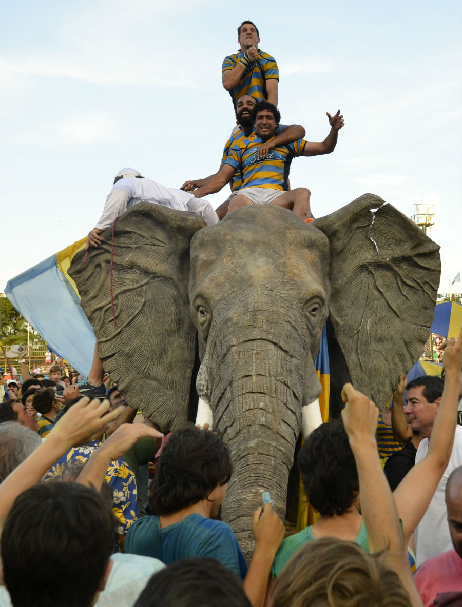 Players of Hindu Club celebrate riding a plastic elephant
