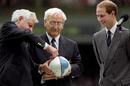 Executive director Ray Williams and Russell Thomas, chairman of the Rugby World Cup, open the ball containing a message from the Headmaster of Rugby School as Prince Edward looks on