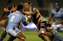 Byron McGuigan is tackled by Northland defenders