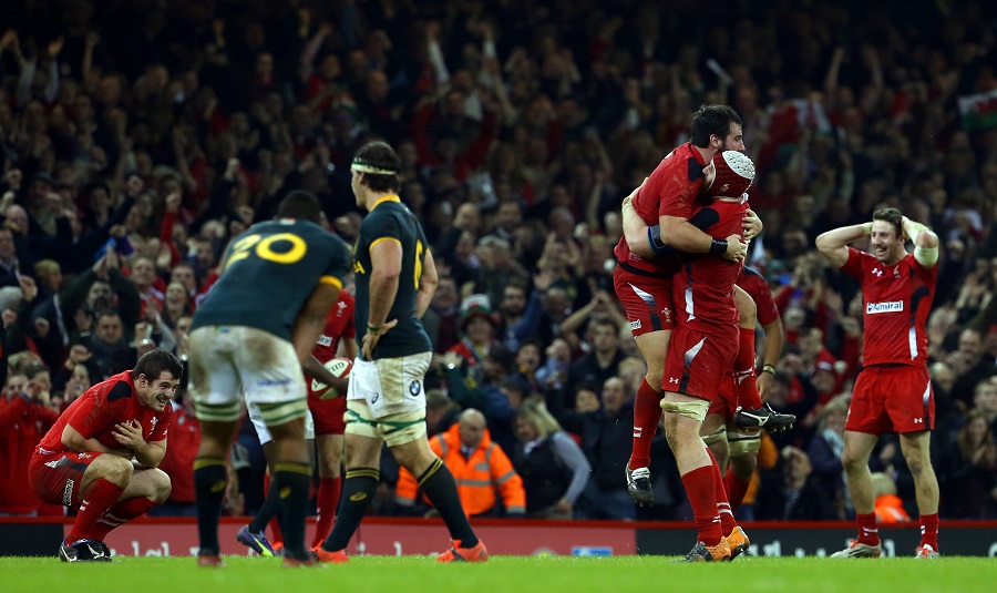 Wales celebrate their victory as the Springboks look on