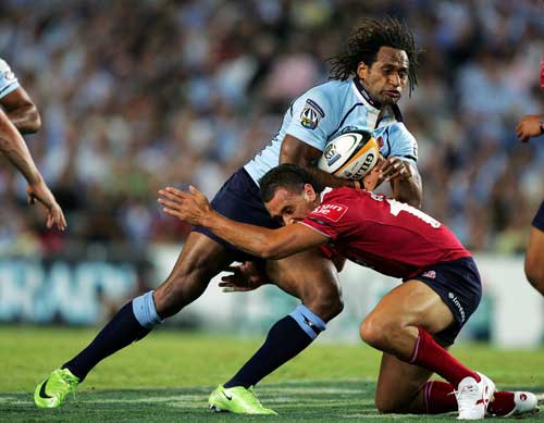 Lote Tuqiri is tackled by Quade Cooper of the Reds Rugby Union Photo 