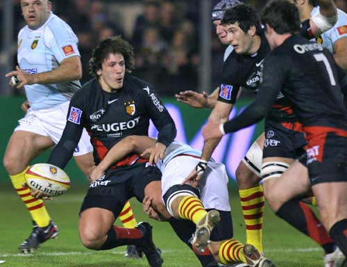 Toulouse centre Remi Lamerat is tackled by the Perpignan defence