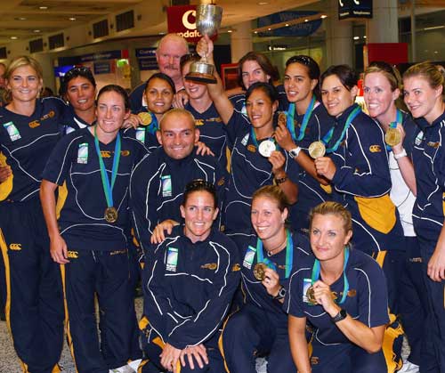 The victorious Australian women's sevens team pose with the Rugby World Cup trophy