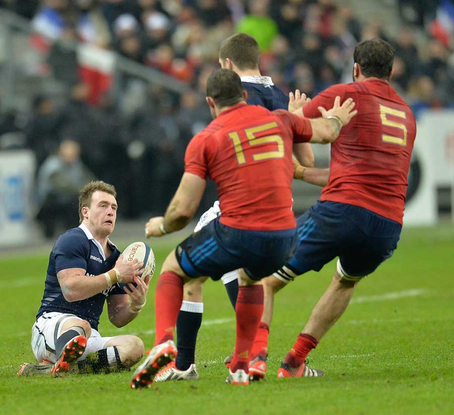 Scotland's Stuart Hogg catches the ball as France close him down