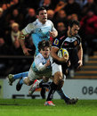 Phil Dollman of Exeter Chiefs makes a break past Simon Hammersley of Newcastle Falcons to score a try