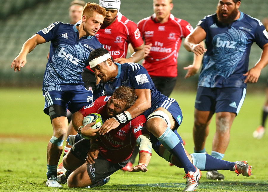 Julian Redelinghuys of the Lions is tackled by Jerome Kaino and Ihaia West of the Blues