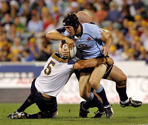 The Waratahs' Sam Norton-Knight is tackled by the Brumbies' Mark Chisholm and Stephen Moore