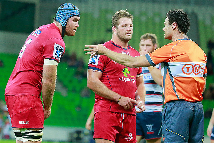 The Reds' James Horwill (L) answers to the referee