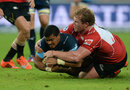 Rudy Paige of the Bulls gets tackled by Jacques van Rooyen
