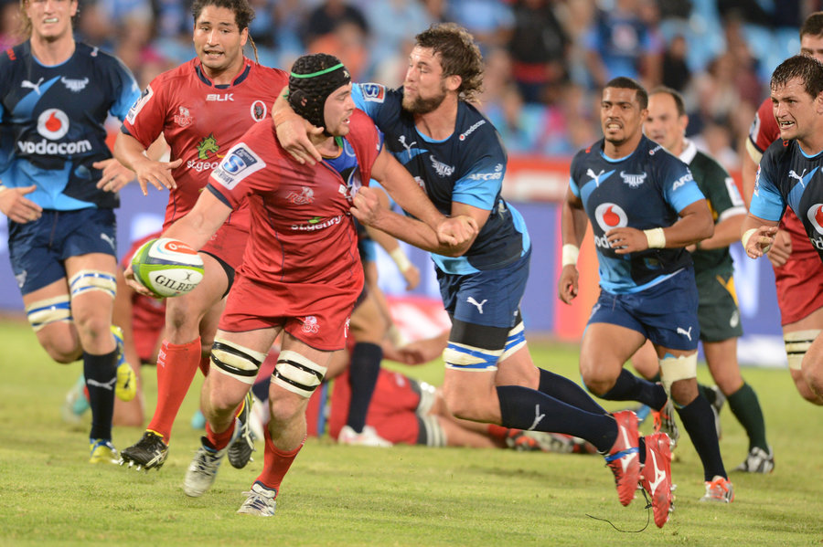 Liam Gill of the Queensland Reds is taken down by the Bulls' defence