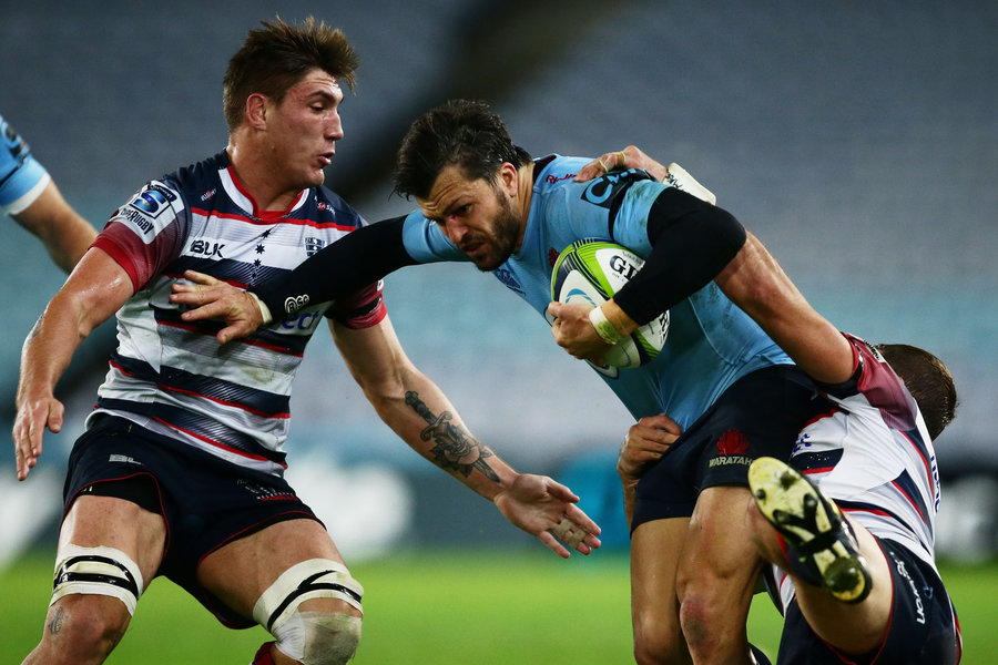 Adam Ashley-Cooper of the Waratahs is taken down by the Rebels defence