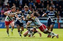 Mark Cueto of Sale is tackled by Harry Sloan and Marland Yarde of Harlequins