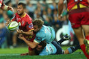 Karmichael Hunt of the Reds is taken down by the Waratahs defence