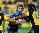 The Bulls' Wynand Olivier is tackled by the Hurricanes' Ma'a Nonu and Karl Lowe 