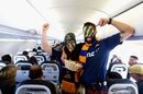 Highlanders fans Ben and Larissa Jamieson hand out sweets on a plane
