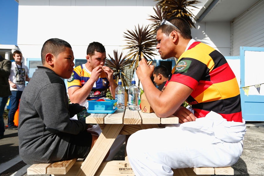 Waikato's Whetu Douglas has lunch with schoolchildren at the table he built during the 2015 ITM Cup season launch