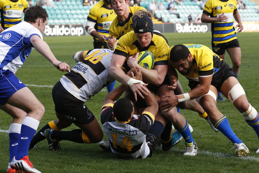 A Sydney Stars player pushes through Perth Spirit's defensive line to push for the try line