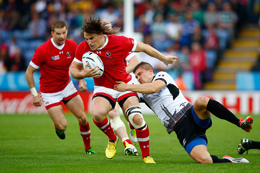 Jeff Hassler of Canada is tackled by Valentin Calafeteanu of Romania