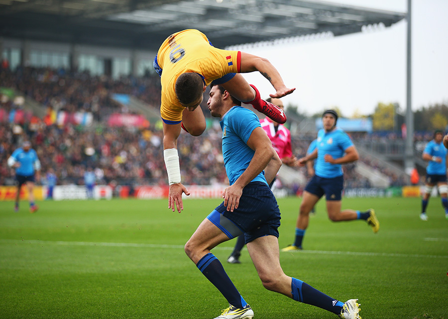 Valentin Calafeteanu of Romania leaps over Leonardo Sarto of Italy as he scores the opening try