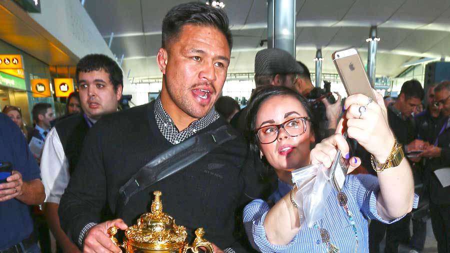 New Zealand's Keven Mealamu poses with an All Blacks supporter, Heathrow Airport, London, November 2, 2015
