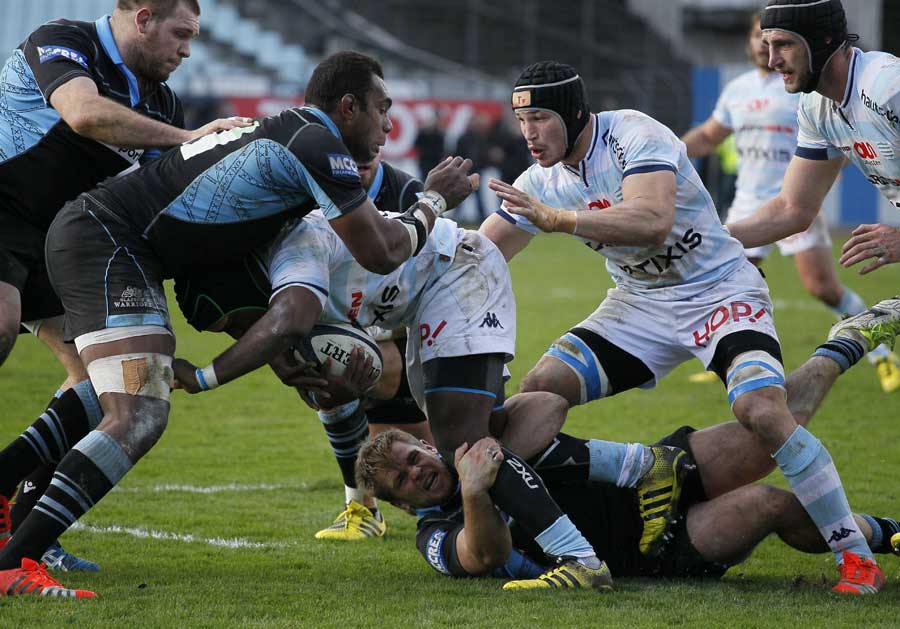 Glasgow Warriors players (L) and Racing Metro's players (R) fight for the ball