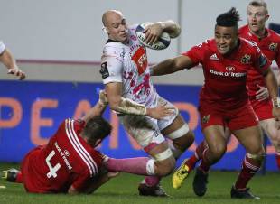 Stade Francais Paris' Italian Number Eight Sergio Parisse (C) is tackled by Munster's Irish lock Dave Foley (L) and Munster's center from New Zealand Francis Saili (R) during the European Champions Cup rugby union match between Stade Francais and Munster Rugby, on January 9, 2016, at the Jean Bouin stadium in Paris.
